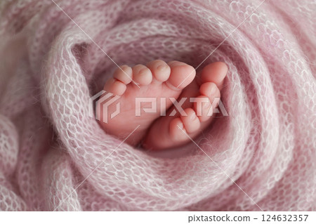 Baby foot on pink soft coverlet, blanket.Close-up of tiny, cute, bare toes, heels and feet of a newborn girl, boy.Detail of a newborn baby legs. Macro horizontal professional studio photo.  124632357