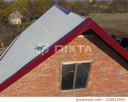 Construction of roof of the house, the corners of the skates of the red metal profile. Construction of roof of the house, the corners of the skates of the red metal profile. 124632464