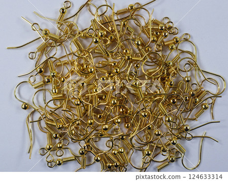 Collection of intricate hooks ready for crafting golden tone earrings by artisan jewelry makers 124633314