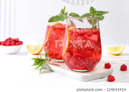 Cold homemade lemonade cocktail, mojito with mint, raspberry and fruits on a sunny table, refreshing summer drink recipe, detox diet and weight loss concept, restaurant menu 124633414