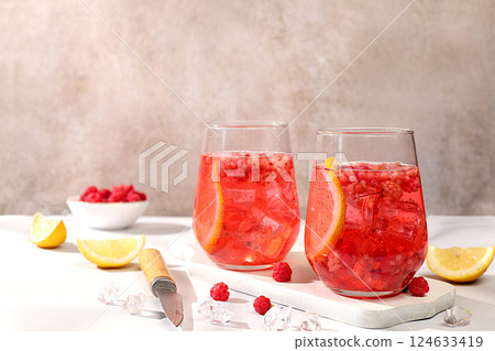 Refreshing summer homemade lemonade cocktail, mojito with raspberry, currant, mint and lemon, weight loss concept, detox water with fruit flavor on light background. healthy and natural food, 124633419