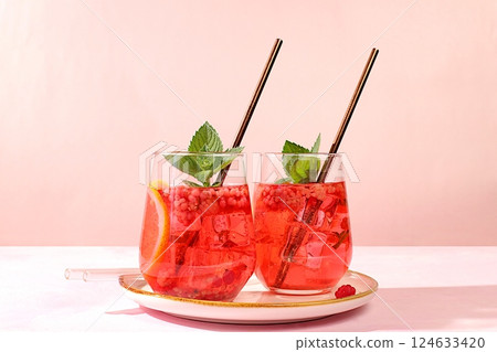 Cold homemade lemonade cocktail, mojito with mint, raspberry and fruits on a sunny table, refreshing summer drink recipe, detox diet and weight loss concept, restaurant menu 124633420