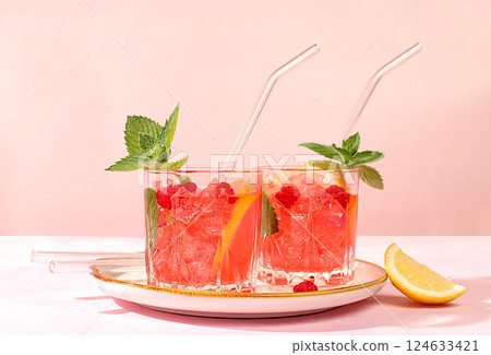 Cold homemade lemonade cocktail, mojito with mint, raspberry and fruits on a sunny table, refreshing summer drink recipe, detox diet and weight loss concept, restaurant menu 124633421