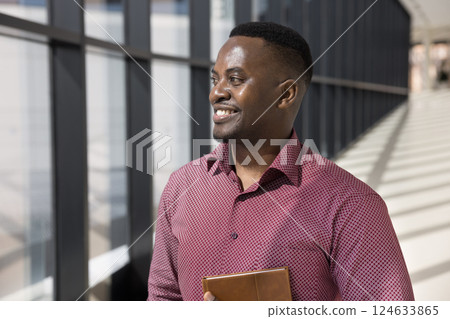 African businessman looking into distance with contented smile 124633865