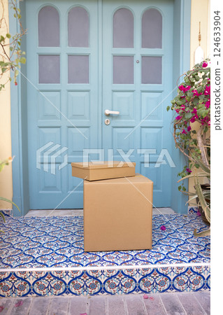 Two cardboard boxes neatly placed at modern residential house doorstep 124633904