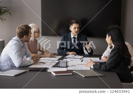 Serious young professional businessman speaking at team meeting Serious young professional businessman speaking at team meeting 124633941