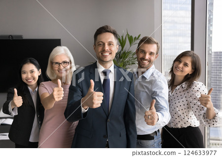 Happy group of professionals looking at camera showing thumbs up Happy group of professionals looking at camera showing thumbs up 124633977