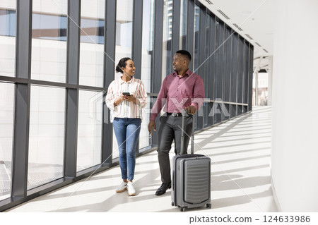 Colleagues travelling together by work, walking through corridor with suitcase Colleagues travelling together by work, walking through corridor with suitcase 124633986