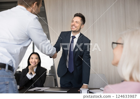 Two happy successful businessmen shake hands, welcoming each other Two happy successful businessmen shake hands, welcoming each other 124633987