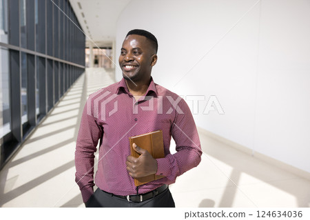 Businessman looking into distance with dreamy, contented smile 124634036
