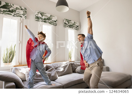 Father and son dressed as superheroes engage in imaginative play 124634065