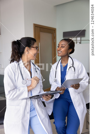 Happy multiethnic hospital colleagues talking in clinic Happy multiethnic hospital colleagues talking in clinic 124634084