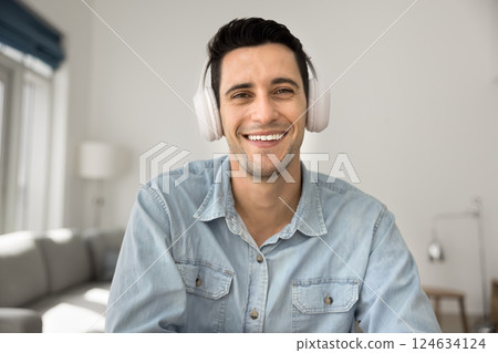 Man wear headphones looking at camera take part in videoconference Man wear headphones looking at camera take part in videoconference 124634124