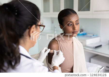 Serious depressed young Black woman visiting doctor for vaccination Serious depressed young Black woman visiting doctor for vaccination 124634128