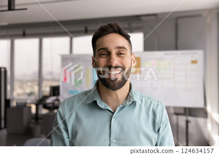 Happy handsome young Hispanic business man posing for head shot 124634157