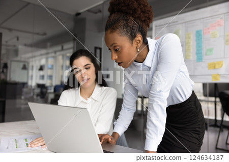 Serious African American expert helping Latin manager with project Serious African American expert helping Latin manager with project 124634187