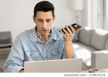 Man holding smartphone lead conversation using speakerphone Man holding smartphone lead conversation using speakerphone 124634216