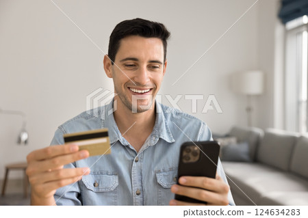 Man using card and phone purchasing through marketplace application Man using card and phone purchasing through marketplace application 124634283