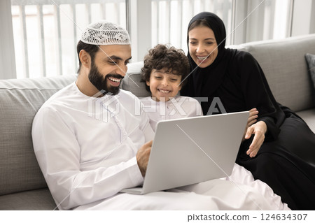Happy Arabic couple with little son enjoy e-shopping at home 124634307