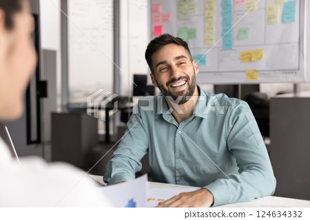 Positive Hispanic project manager man meeting with colleagues off screen Positive Hispanic project manager man meeting with colleagues off screen 124634332