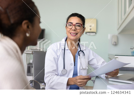 Happy positive senior doctor woman talking to Black female patient 124634341