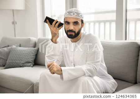 Arabic man lead talk on speakerphone, or listening received message 124634365