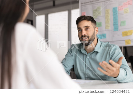 Positive young Latin business professional man talking to employer Positive young Latin business professional man talking to employer 124634431