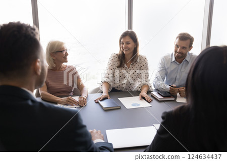 Young and mature teammates listening millennial female meeting participant 124634437