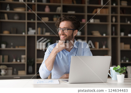 Smiling young man look aside from notebook visualize work result Smiling young man look aside from notebook visualize work result 124634483