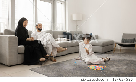 Muslim family spend pastime together in modern living room Muslim family spend pastime together in modern living room 124634586