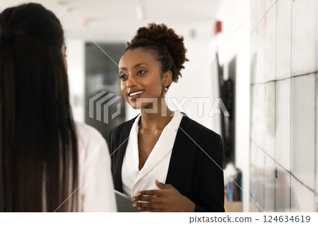 Happy beautiful young business professional woman talking to work colleague Happy beautiful young business professional woman talking to work colleague 124634619