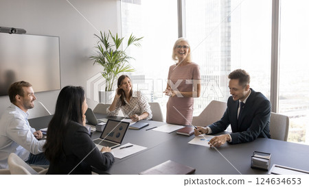 Older businesswoman leading discussion with shareholders in boardroom 124634653