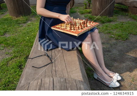 Caucasian woman playing chess outdoors. 124634915