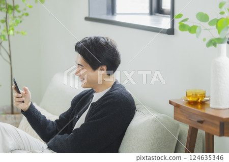 A man who uses a smartphone in the living room 124635346