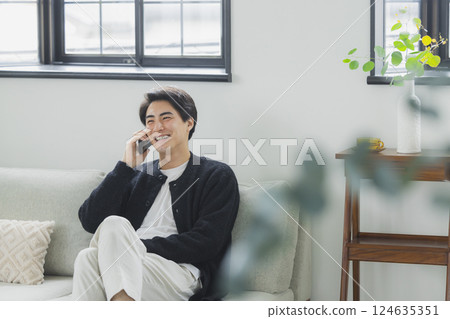 A man who uses a smartphone in the living room 124635351