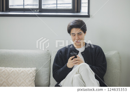 A man who uses a smartphone in the living room 124635353