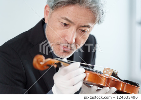 Musical instrument repairman repairing a violin 124635490