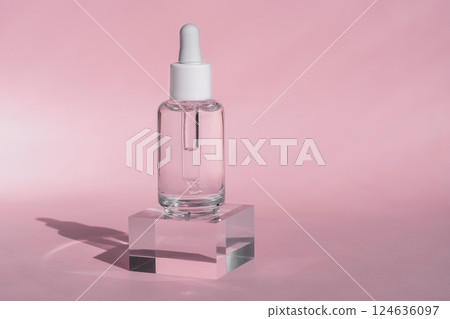 Clear Serum Dropper Bottle on Acrylic Block with Pink Background Clear Serum Dropper Bottle on Acrylic Block with Pink Background 124636097