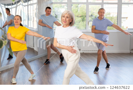 Portrait of active mature people enjoying modern energetic dancing in a group in studio Portrait of active mature people enjoying modern energetic dancing in a group in studio 124637622