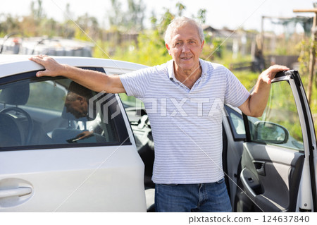 Elderly man posing by car in garden 124637840