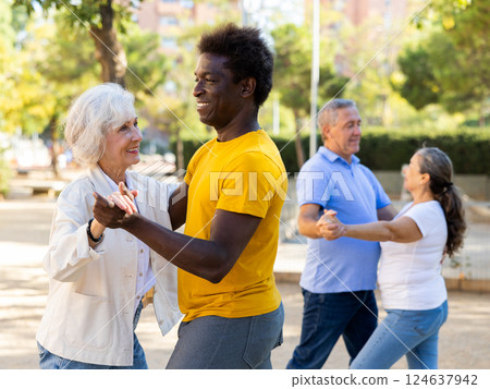 Happy positive smiling adult friends dancing pair dance in garden 124637942