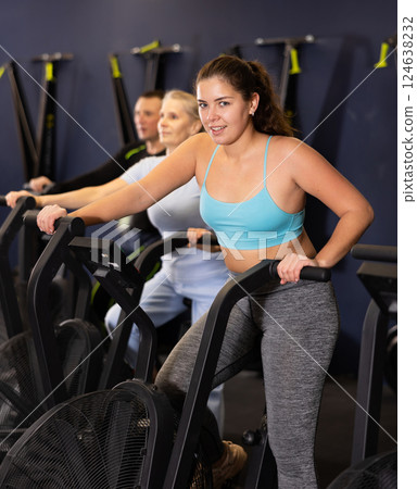 Fit young woman working out at elliptical machine in gym 124638232