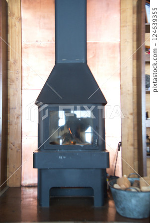 Wood fired stove with fire-wood fire-irons and briquettes from bark. 124639355