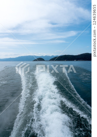 A distant view of Okishima and the white wake of an Okishima ferry 124639655
