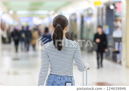 A woman walking inside the station, back view 124639946