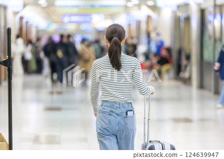 A woman walking inside the station, back view 124639947