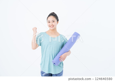 Young woman with a yoga mat Young woman with a yoga mat 124640380