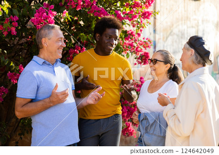 Happy multiracial couples discussing events at sunny day in the park 124642049