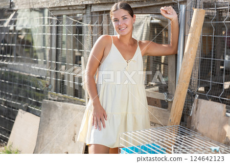 Young woman posing near hen house 124642123