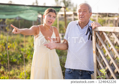 Young European woman and senior man neighbors quarrel and swear Young European woman and senior man neighbors quarrel and swear 124642226